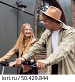 beautiful couple outdoors city with electric scooters. Стоковое фото, агентство Ingram Publishing / Фотобанк Лори