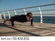 man doing push ups activewear by beach. Стоковое фото, агентство Ingram Publishing / Фотобанк Лори