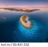 Aerial view of small island, Kamenjak cape, Adriatic sea, Croatia at sunset in summer. Beautiful landscape with sea coast, mountains, clear water, purple sky at twilight. Top view from drone. Panorama. Aerial view of small island, Kamenjak cape, Adriatic sea, Croatia. Стоковое фото, агентство Ingram Publishing / Фотобанк Лори