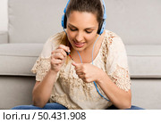 Beautiful woman at home making a pause to painting her nails while listening music. Стоковое фото, агентство Ingram Publishing / Фотобанк Лори