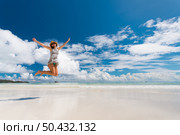 Beautiful woman jumping on the wonderful beach of Praslin, Seychelles. Стоковое фото, агентство Ingram Publishing / Фотобанк Лори