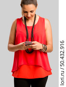 Beautiful woman texting a sms, isolated over gray background. Стоковое фото, агентство Ingram Publishing / Фотобанк Лори