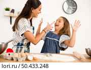 Shot of a mother and daughter having fun in the kitchen and learning to make a cake. Стоковое фото, агентство Ingram Publishing / Фотобанк Лори