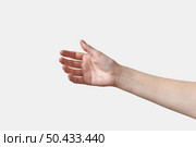 Female hand reaching or taking something, holding invisible object, gentle, soft touch isolated on white background. Soft grab action woman hand.. Horizontal reaching or holding female hand on white. Стоковое фото, агентство Ingram Publishing / Фотобанк Лори