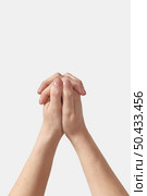 Female hands folded into a lock, protection, gentle care something hidden inside with two manicured thumbs on top isolated on white background.. Two female hands in hand lock on white. Стоковое фото, агентство Ingram Publishing / Фотобанк Лори