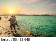 Fishermen fishing on the Bosphorus at sunset. Fishermen fishing in Istanbul. Стоковое фото, агентство Ingram Publishing / Фотобанк Лори