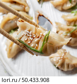 close up sticks holding asian food. Стоковое фото, агентство Ingram Publishing / Фотобанк Лори
