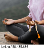 woman doing yoga holding rosary. Стоковое фото, агентство Ingram Publishing / Фотобанк Лори