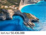 Aerial view of blue sea, mountains, white sandy beach at sunrise in summer. Porto Katsiki, Lefkada island, Greece. Beautiful landscape with sea coast, yacht, rocks, azure water, green forest. Top view. Стоковое фото, агентство Ingram Publishing / Фотобанк Лори