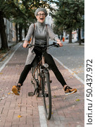 cute woman fooling around her bike 2. Стоковое фото, агентство Ingram Publishing / Фотобанк Лори