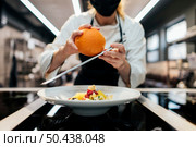 female chef grating orange peel dish. Стоковое фото, агентство Ingram Publishing / Фотобанк Лори