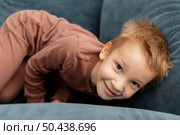 little kid staying sofa. Стоковое фото, агентство Ingram Publishing / Фотобанк Лори