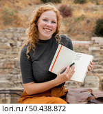 mid shot woman showing journal. Стоковое фото, агентство Ingram Publishing / Фотобанк Лори