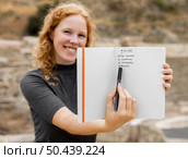 redhead woman showing journal. Стоковое фото, агентство Ingram Publishing / Фотобанк Лори