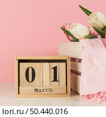wooden 1st march calendar near crate with scarf tulips against pink background. Стоковое фото, агентство Ingram Publishing / Фотобанк Лори