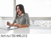 amazed woman sitting table with laptop. Стоковое фото, агентство Ingram Publishing / Фотобанк Лори