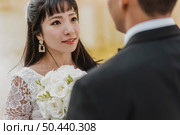 beautiful bride looking into groom s eyes while holding bouquet. Стоковое фото, агентство Ingram Publishing / Фотобанк Лори