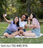 female friends together park taking selfie. Стоковое фото, агентство Ingram Publishing / Фотобанк Лори