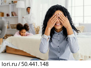 front view smiley mother playing hide seek with her children. Стоковое фото, агентство Ingram Publishing / Фотобанк Лори