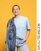 smiley woman posing with denim jacket. Стоковое фото, агентство Ingram Publishing / Фотобанк Лори
