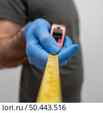 defocused man with gloves holding tape measurer social distancing. Стоковое фото, агентство Ingram Publishing / Фотобанк Лори