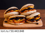four arepas with delicious filling chopping board. Стоковое фото, агентство Ingram Publishing / Фотобанк Лори