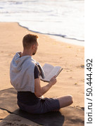 man reading meditating beach. Стоковое фото, агентство Ingram Publishing / Фотобанк Лори