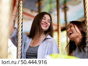 smiley female friends carousel. Стоковое фото, агентство Ingram Publishing / Фотобанк Лори