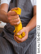 front view man squeezing cloth from natural pigment. Стоковое фото, агентство Ingram Publishing / Фотобанк Лори