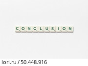 Conclusion word formed of scrabble tiles on white background. Minimal business design with creative lettering.. Conclusion formed of scrabble tiles on white background. Стоковое фото, агентство Ingram Publishing / Фотобанк Лори