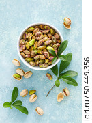 Pistachios. Whole pistachios with green leaves and pistachio nut kernels. Healthy natural vegetarian organic food. Top view, copy space. Стоковое фото, агентство Ingram Publishing / Фотобанк Лори