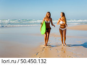 Best friends enjoying the summer, running on the beach with a surfboard. Стоковое фото, агентство Ingram Publishing / Фотобанк Лори