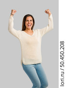Studio shot of a happy young woman with arms raised. Стоковое фото, агентство Ingram Publishing / Фотобанк Лори