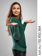 Beautiful woman standing over a gray background with arms open and smiling. Стоковое фото, агентство Ingram Publishing / Фотобанк Лори