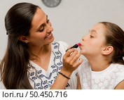 Mother playing with her daughter applying lipstick. Стоковое фото, агентство Ingram Publishing / Фотобанк Лори