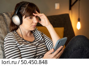Woman on bed at phone with symptoms of depression. Стоковое фото, агентство Ingram Publishing / Фотобанк Лори