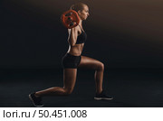Shot of a beautiful young woman in a workout gear lifting weights. Стоковое фото, агентство Ingram Publishing / Фотобанк Лори