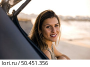 Beautiful woman sitting in the trunk of a car near a beach and smilling. Стоковое фото, агентство Ingram Publishing / Фотобанк Лори