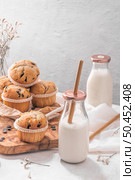 Chocolate chip muffins with milk served on glass bottles on white kitchen countertop. Стоковое фото, агентство Ingram Publishing / Фотобанк Лори