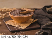 Brown lentils in a ceramic bowl with a wooden scoop on a kitchen countertop. Стоковое фото, агентство Ingram Publishing / Фотобанк Лори
