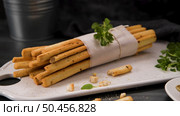 Fresh baked homemade grissini bread sticks in white ceramic tray with olive oil and basil herbs over kitchen counter top. Стоковое фото, агентство Ingram Publishing / Фотобанк Лори