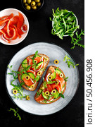 Toasts with salted salmon, arugula, green olives and cucumber, top down view. Стоковое фото, агентство Ingram Publishing / Фотобанк Лори