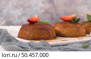 Caramel custard puddings on white ceramic tray and kitchen countertop. Стоковое фото, агентство Ingram Publishing / Фотобанк Лори