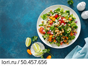 Tabbouleh salad. Tabouli salad with fresh parsley, onions, tomatoes, bulgur and chickpea. Healthy vegetarian food, diet. Top view. Стоковое фото, агентство Ingram Publishing / Фотобанк Лори