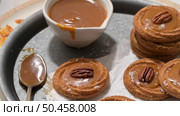 Caramel cookies with pecan nuts served on roud plates, in the kitchen after baking. Стоковое фото, агентство Ingram Publishing / Фотобанк Лори