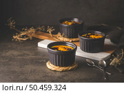 Creme brulee. Bowls with French vanilla cream dessert with caramelised sugar on top, spoons, dark rustic table. Стоковое фото, агентство Ingram Publishing / Фотобанк Лори