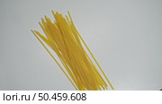 A small amount of spaghetti, in its dry, uncooked state, is spread out on the table. Стоковое видео, видеограф Strunov David / Фотобанк Лори