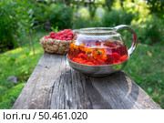 Чайник   ягодного чая с малиной, календулой и мятой и корзинка с малиной. Стоковое фото, фотограф Лариса Веселова / Фотобанк Лори