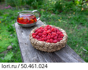 Малина в плетеной корзинке с чаем  из малины, календулы и мяты  на деревянной скамейке. Стоковое фото, фотограф Лариса Веселова / Фотобанк Лори