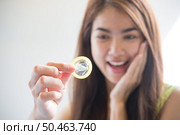 Young woman holding condom prevent pregnancy and Sexually transmitted diseases. Стоковое фото, агентство Ingram Publishing / Фотобанк Лори